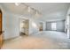 Open floor plan living room with built-ins and neutral carpet leading to kitchen at 7532 Red Oak Ln, Charlotte, NC 28226