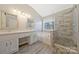 Bathroom featuring a double sink vanity, soaking tub, walk-in shower, and plenty of natural light at 8430 Forest Shadow Cir, Cornelius, NC 28031