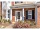 Inviting front porch features brick accents, white columns, and manicured shrubs leading to the entrance at 8430 Forest Shadow Cir, Cornelius, NC 28031