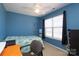 Blue bedroom with a ceiling fan, natural light, and a mirror with a treadmill in the corner at 920 Lakehill Rd, Charlotte, NC 28214