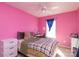 Pink bedroom with a plaid bedspread, desk, and white dresser provides a charming personal space at 920 Lakehill Rd, Charlotte, NC 28214