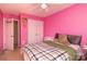 Bedroom with pink walls features a bed, closet, and doorway to another room at 920 Lakehill Rd, Charlotte, NC 28214