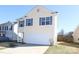 Two story home with a white garage door and light yellow siding at 920 Lakehill Rd, Charlotte, NC 28214