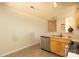 Well-lit kitchen featuring a stainless steel dishwasher, sink, and light wood cabinets at 920 Lakehill Rd, Charlotte, NC 28214