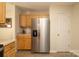 Bright kitchen with stainless steel refrigerator, light wood cabinets, and neutral countertops at 920 Lakehill Rd, Charlotte, NC 28214