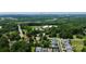 Aerial view shows property, its location with arrow, and Lake Norman in the background, surrounded by mature trees at 9808 Washam Potts Rd, Cornelius, NC 28031