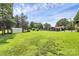 This backyard showcases a lush lawn, storage buildings, and mature trees, creating a serene outdoor space at 9808 Washam Potts Rd, Cornelius, NC 28031