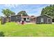 Backyard features a patio with seating, a firepit, beautiful green grass, and mature trees at 9808 Washam Potts Rd, Cornelius, NC 28031
