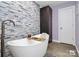 Spa-like bathroom featuring a soaking tub, freestanding faucet, and modern stone accents at 9808 Washam Potts Rd, Cornelius, NC 28031