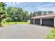 Spacious driveway leading to a two-car garage and large backyard with mature trees at 9808 Washam Potts Rd, Cornelius, NC 28031