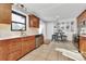 Sunlit kitchen boasts wooden cabinets, stainless appliances, and a cozy breakfast nook at 9808 Washam Potts Rd, Cornelius, NC 28031