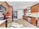Well-lit kitchen featuring wooden cabinets, stainless steel appliances, and ceramic tile flooring at 9808 Washam Potts Rd, Cornelius, NC 28031