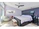 Bright main bedroom featuring hardwood floors, a ceiling fan, and a decorative accent wall at 9808 Washam Potts Rd, Cornelius, NC 28031