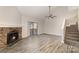 Living room featuring a stone fireplace, ceiling fan, wood floors, and stairway at 100 Willow Run Dr # 7, Gastonia, NC 28056