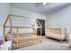 Bright bedroom featuring a wooden playhouse bed, crib, neutral color scheme, and ceiling fan at 1013 Oakmont Dr, Rock Hill, SC 29732