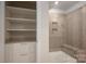 Modern glass shower with tile surround and built-in bench, next to storage shelves at 1038 Amberley Crossing Dr, Belmont, NC 28012