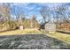 Large backyard with a greenhouse and storage shed surrounded by mature trees at 1061 Gaither Nw Pl, Concord, NC 28027
