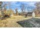 Spacious backyard featuring a greenhouse and shed against a backdrop of mature trees at 1061 Gaither Nw Pl, Concord, NC 28027