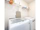 Functional laundry room with modern washer and dryer units, shelving, and space-saving ironing board at 11440 Westbranch Pkwy, Davidson, NC 28036