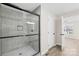 Modern walk-in shower featuring gray tile and a glass door leading to a bedroom at 120 Roger Dr, Statesville, NC 28625