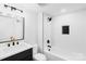 Modern bathroom features sleek, dark vanity with gold hardware, complemented by a bright white tiled shower and tub at 1324 Southampton St, Shelby, NC 28152