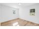 Bright bedroom with hardwood flooring, white walls, and natural light from two large windows at 1324 Southampton St, Shelby, NC 28152