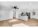 Open concept living room view into kitchen with modern ceiling fan and hardwood floors at 1324 Southampton St, Shelby, NC 28152