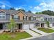 Charming townhome exteriors featuring stone accents, covered entries, and well-maintained landscaping on a beautiful sunny day at 13529 Browhill Ln, Charlotte, NC 28278