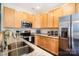 Well-appointed kitchen featuring light wood cabinets, granite countertops, and stainless steel appliances at 13529 Browhill Ln, Charlotte, NC 28278