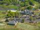 Aerial view of the clubhouse and grounds including the surrounding golf course, ponds and parking at 13822 Tributary Ct, Davidson, NC 28036
