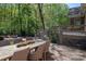 Inviting backyard patio with an outdoor dining area and steps up to a raised deck overlooking the landscaped yard at 13822 Tributary Ct, Davidson, NC 28036