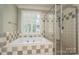 Bathroom featuring a soaking tub with tiled surround and glass-enclosed shower at 13822 Tributary Ct, Davidson, NC 28036