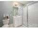 Bathroom with white cabinets, large mirror, and glass-enclosed shower at 13822 Tributary Ct, Davidson, NC 28036