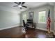 This bedroom features a ceiling fan, hardwood floors, and two windows for natural light at 13822 Tributary Ct, Davidson, NC 28036
