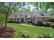 Charming brick home with a landscaped yard, inviting walkway, dormer windows and covered front porch with white columns at 13822 Tributary Ct, Davidson, NC 28036