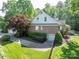Brick home with a well-kept lawn, landscaping, and attached garage at 13822 Tributary Ct, Davidson, NC 28036