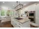 Bright kitchen with granite countertops, stainless steel appliances, cooktop island, and adjacent breakfast nook with natural light at 13822 Tributary Ct, Davidson, NC 28036