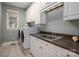 Well-lit laundry room featuring modern washer and dryer, utility sink and ample storage at 13822 Tributary Ct, Davidson, NC 28036