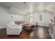 The living room is spacious, with white walls and hardwood floors. Features a couch, chairs, and ottoman at 13822 Tributary Ct, Davidson, NC 28036