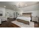 This main bedroom offers a luxury aesthetic with a chandelier, white walls, and hardwood flooring at 13822 Tributary Ct, Davidson, NC 28036