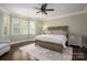 Comfortable primary bedroom featuring a decorative ceiling fan and plantation shutters for natural light control at 13822 Tributary Ct, Davidson, NC 28036