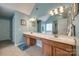 Bathroom featuring a double vanity and a large mirror with soft blue walls at 1404 Peachcroft Rd, Charlotte, NC 28216