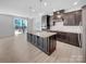 The modern kitchen features an island with sink, lots of cabinets and stainless steel appliances at 14106 Ridgewater Way, Charlotte, NC 28278
