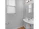 Well-lit half bathroom with a pedestal sink, large mirror, and hardwood floors at 14106 Ridgewater Way, Charlotte, NC 28278