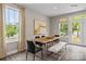 Well-lit dining area with a wooden table, modern chairs, bench, and large windows with curtains at 15340 Ballancroft Pkwy # 15, Charlotte, NC 28277