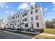 Modern townhomes featuring white exteriors and black-framed windows on a sunny day at 15340 Ballancroft Pkwy # 15, Charlotte, NC 28277