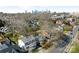 Aerial view of the house with city skyline, mature trees, and well-maintained neighborhood at 2028 Scott Ave, Charlotte, NC 28203