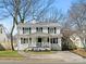 Charming two-story white home with black shutters and a welcoming front porch with a decorative railing at 2028 Scott Ave, Charlotte, NC 28203