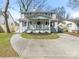 Classic white two-story home with a cozy front porch featuring a swing and a well-manicured front yard at 2028 Scott Ave, Charlotte, NC 28203