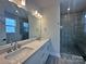 Bathroom featuring double sink vanity and tiled walk-in shower at 2035 Clarksdale Dr # 33, Charlotte, NC 28206